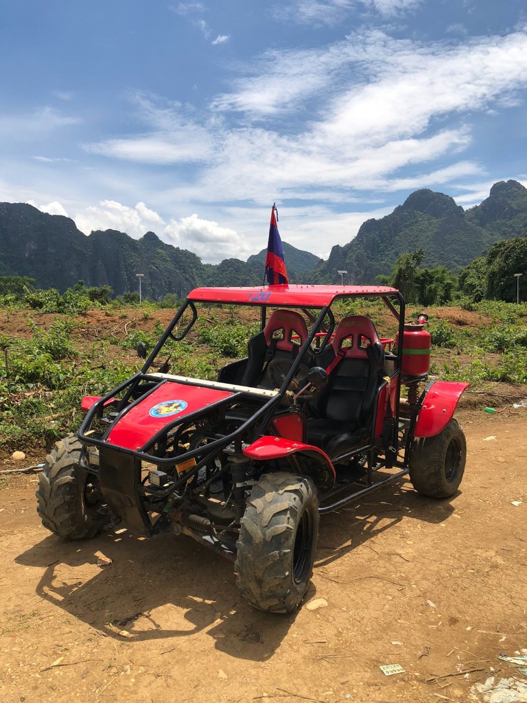 Red buggy on a trail with mountain backdrop