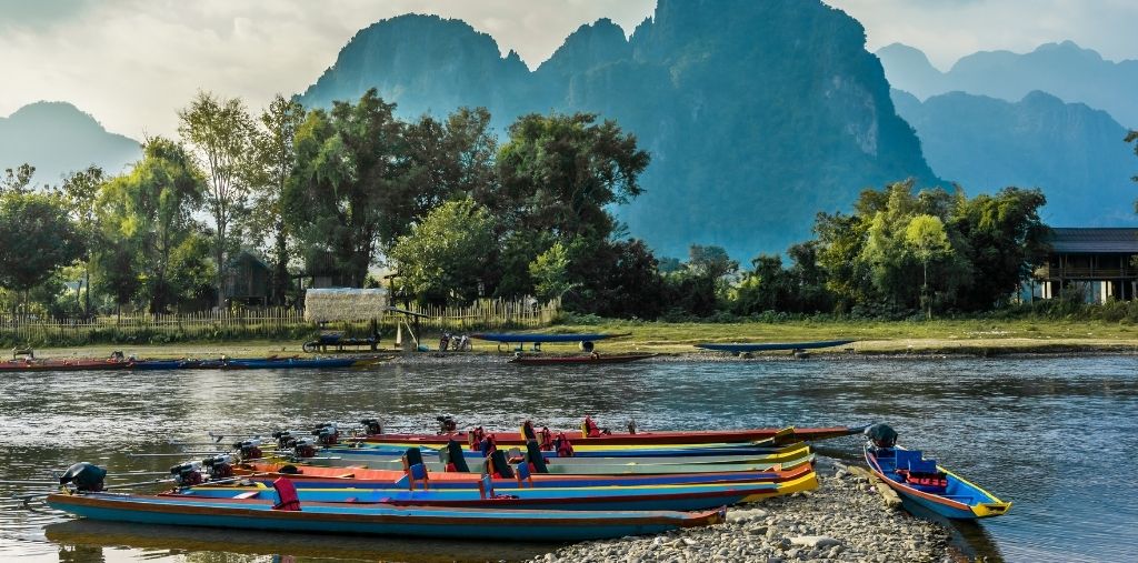 Colorful boats on the Nam Song River with karst mountains
